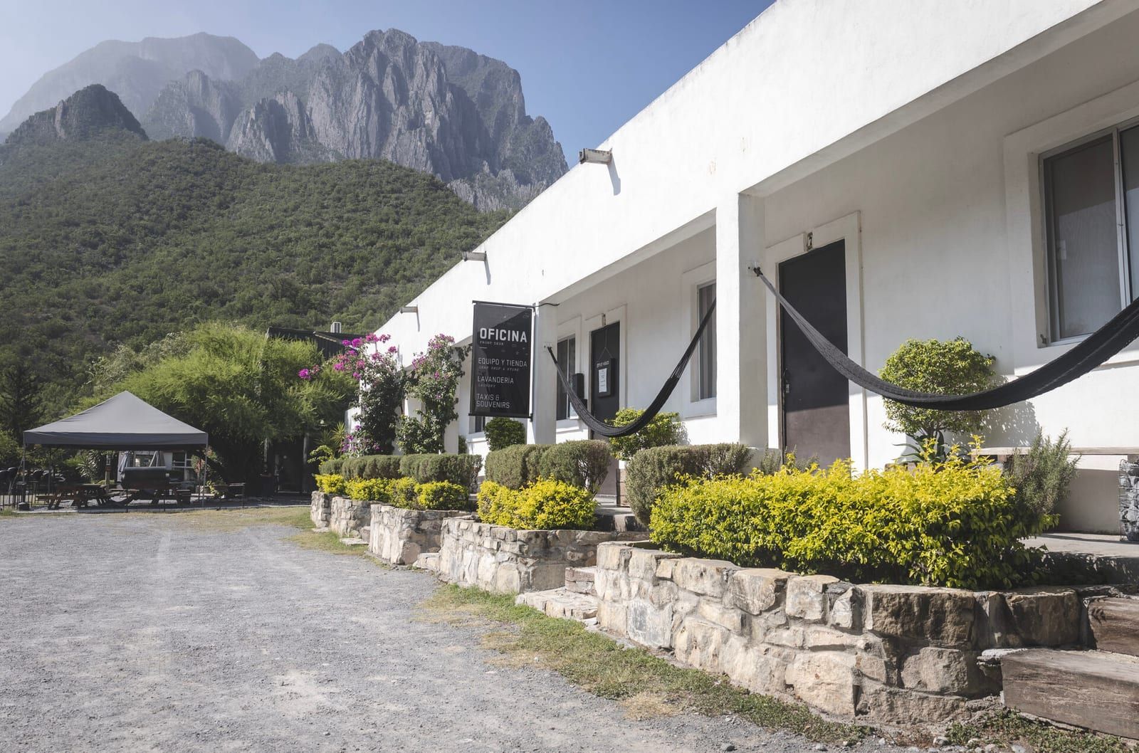 La entrada de la posada con el letrero de oficina y la montaña detrás