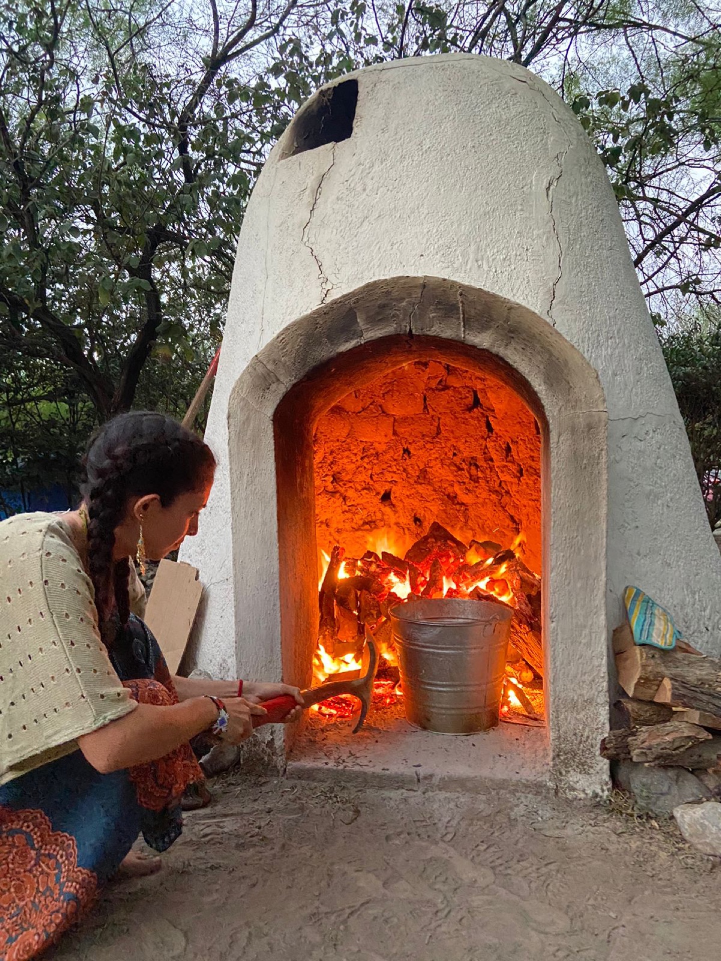 Mujer atendiendo el fogón del temazcal