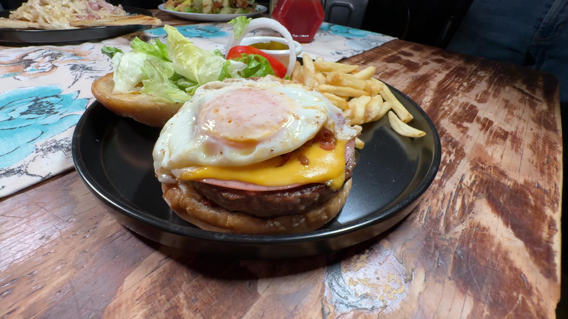 Hamburguesa con huevo y papas servida en el restaurante